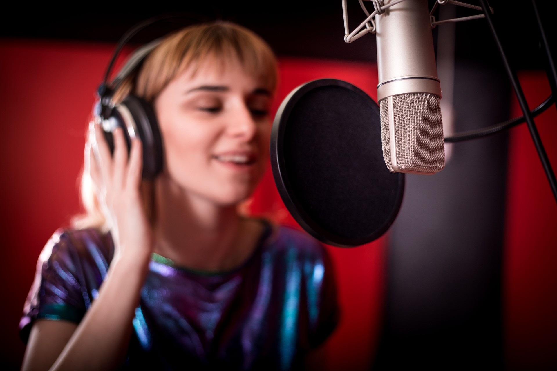 Young singer woman during music session at recording studio