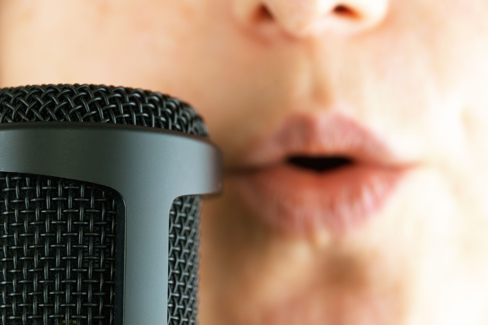 Close-up of female singer's lips and microphone during vocal performance